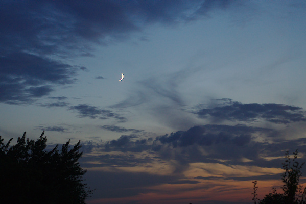 moon in the sky with some clouds and sunset colours