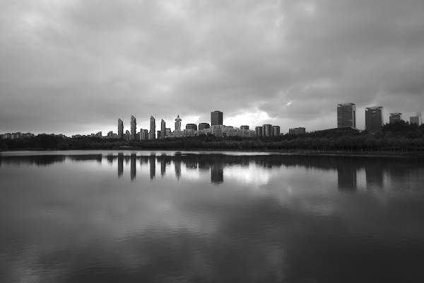 reflection of buildings and clouds in a lake
