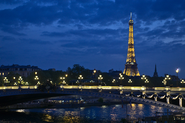 Eiffel tower behind a bridge in twilight