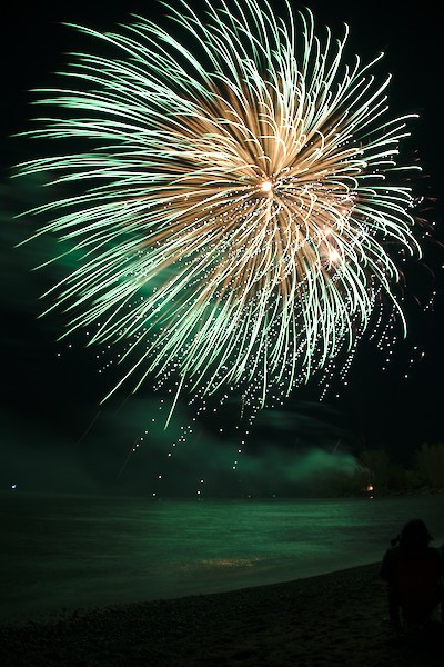 green fireworks over the lake and beach