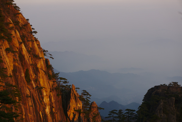 first sunlight on a mountain with more mountain ranges in the distance