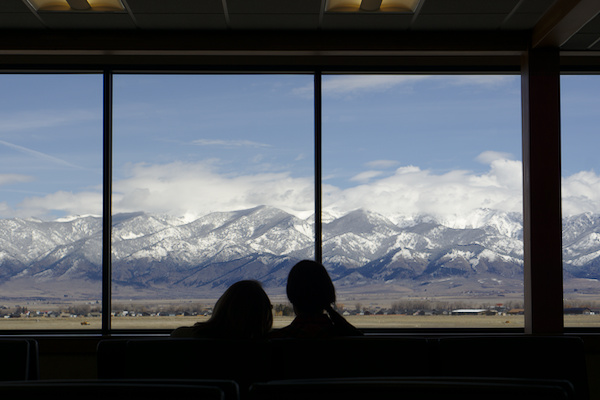 two women sitting in front of a panorama window with mountain view