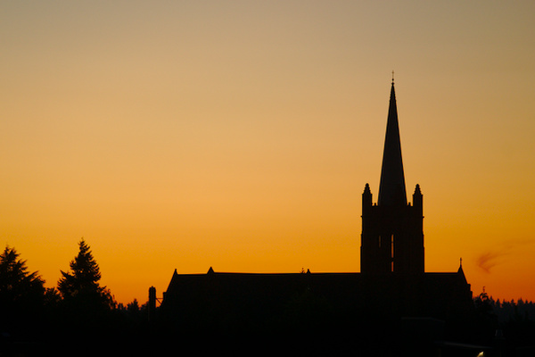 church and some trees in front of yellowish sky