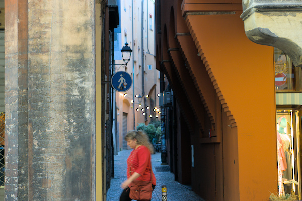 woman in front of the entrance to a narrow alley