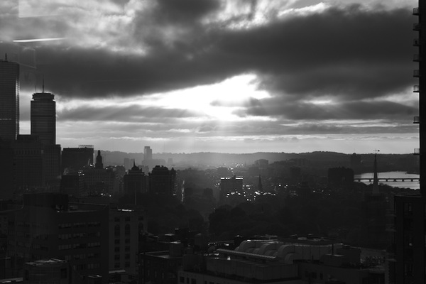 sun shining through the clouds over Boston's skyline (black/white)