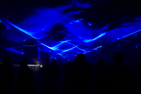 people between bridge pillars with reflection of blue light in smoke